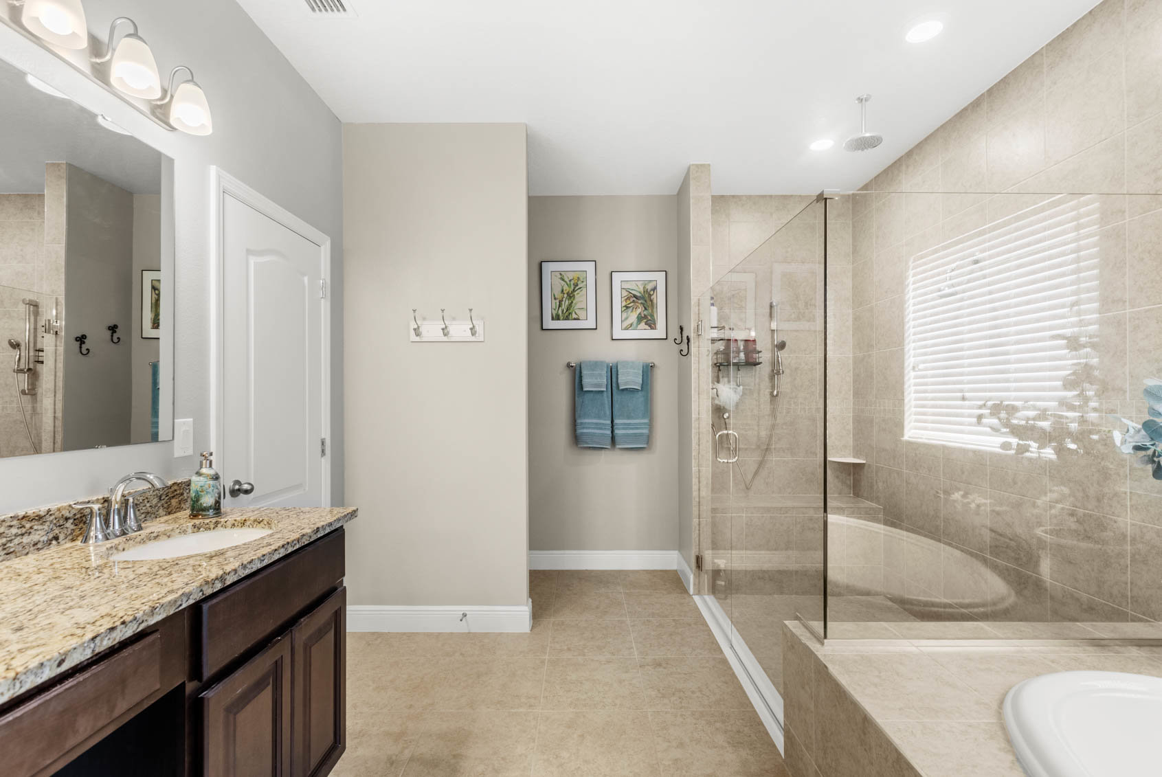 primary bathroom with glass shower and beige walls